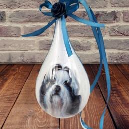 Bombka łezka z psem Shih Tzu zawieszona na tle ceglanej ściany